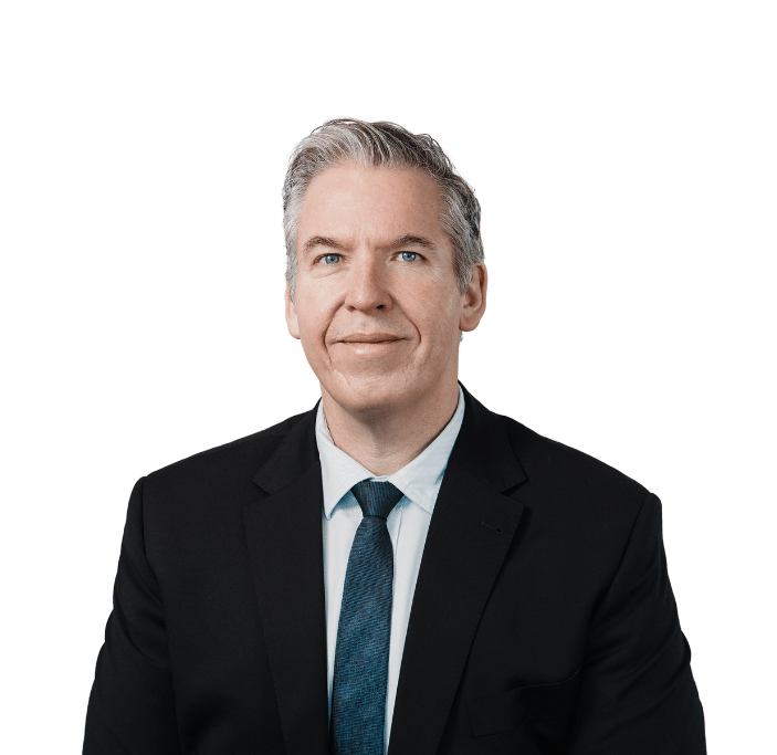 man in suit with blue tie smiling at camera