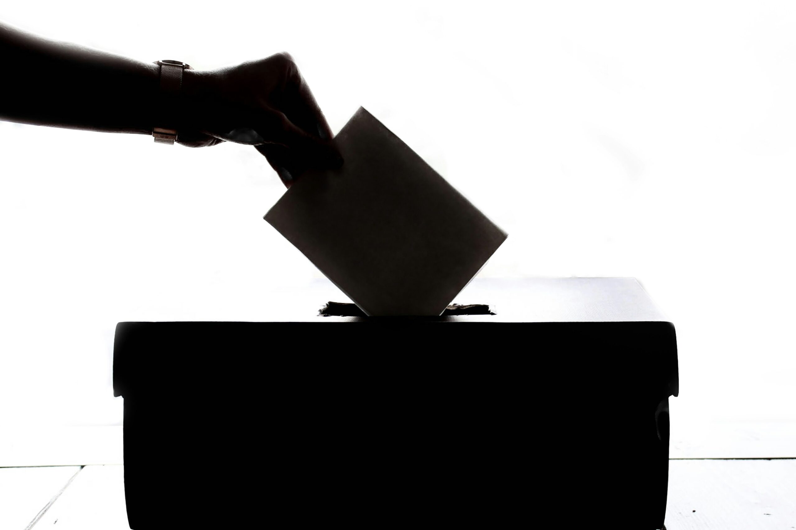 hand putting ballot in ballot box