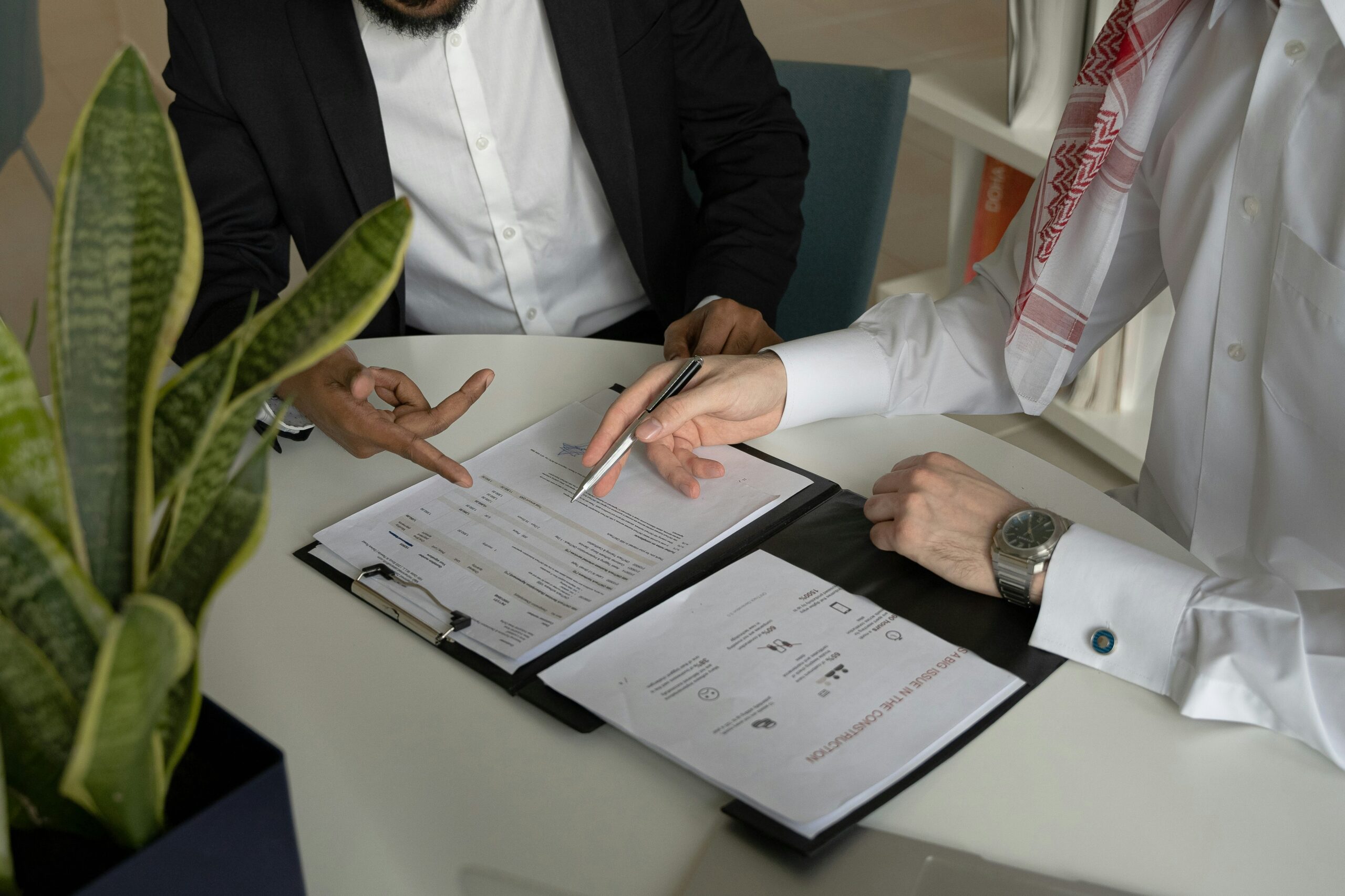 Two people sitting a table looking over some paperwork