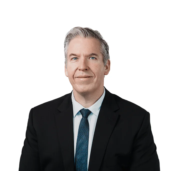 man in suit with blue tie smiling at camera