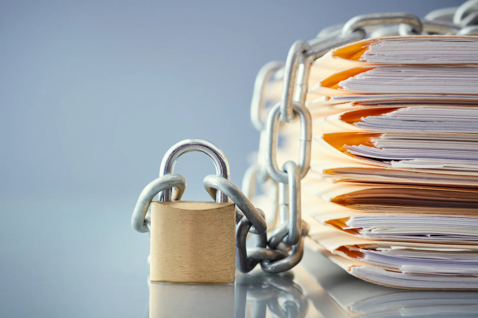 pad lock connecting a chain that is wrapped around a pile of files
